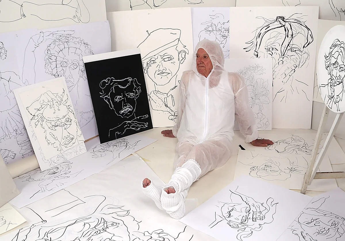 El padre del artista, sentado entre los dibujos de Eduardo Sourrouille en el Espacio Marzana