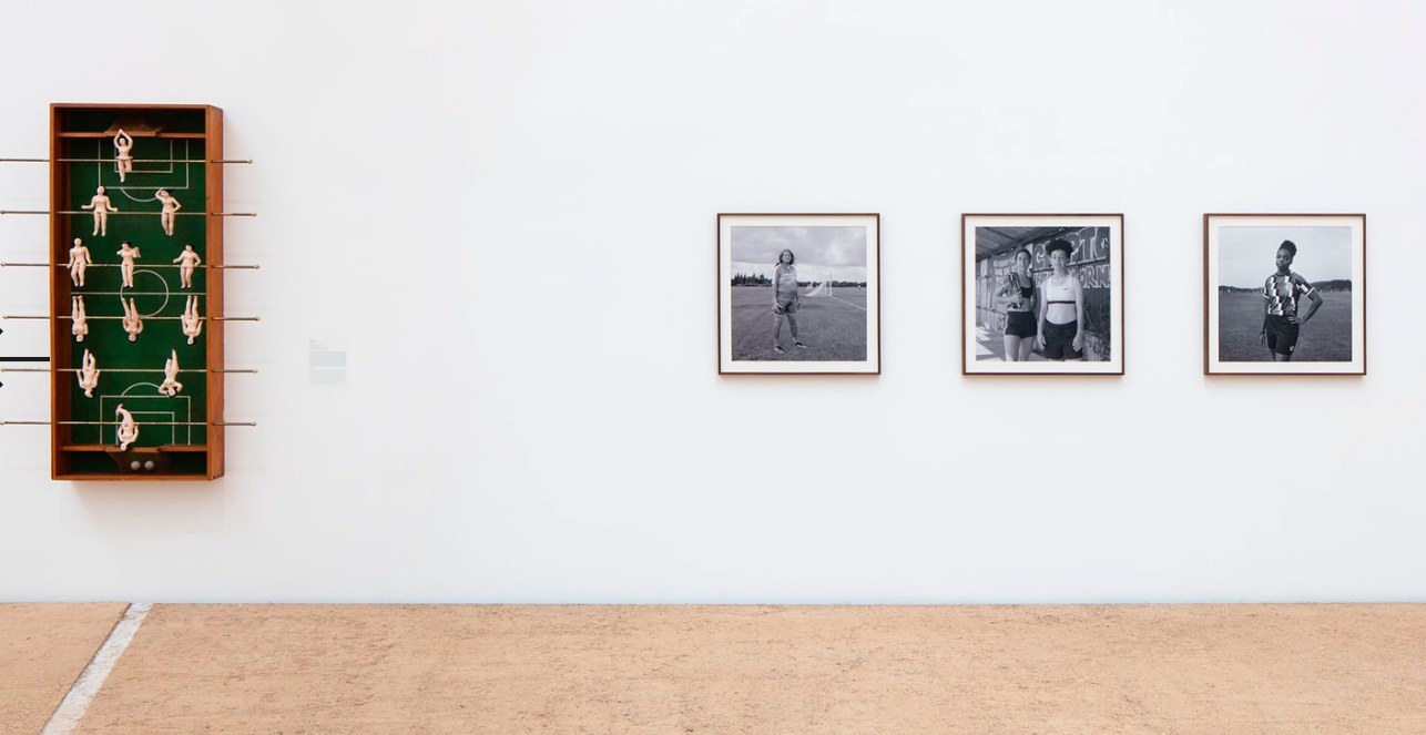Futbolín de pared con figuras y retratos en blanco y negro de futbolistas