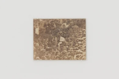 Pequeña fotografía sepia enmarcada de una multitud