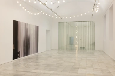 Vista general de sala con una gran fotografía, una guirnalda de luces y una cortina de cuentas de vidrio
