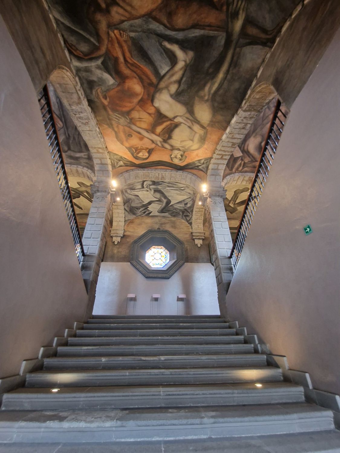 Cubo de la escalera con murales de Orozco y vitral octagonal
