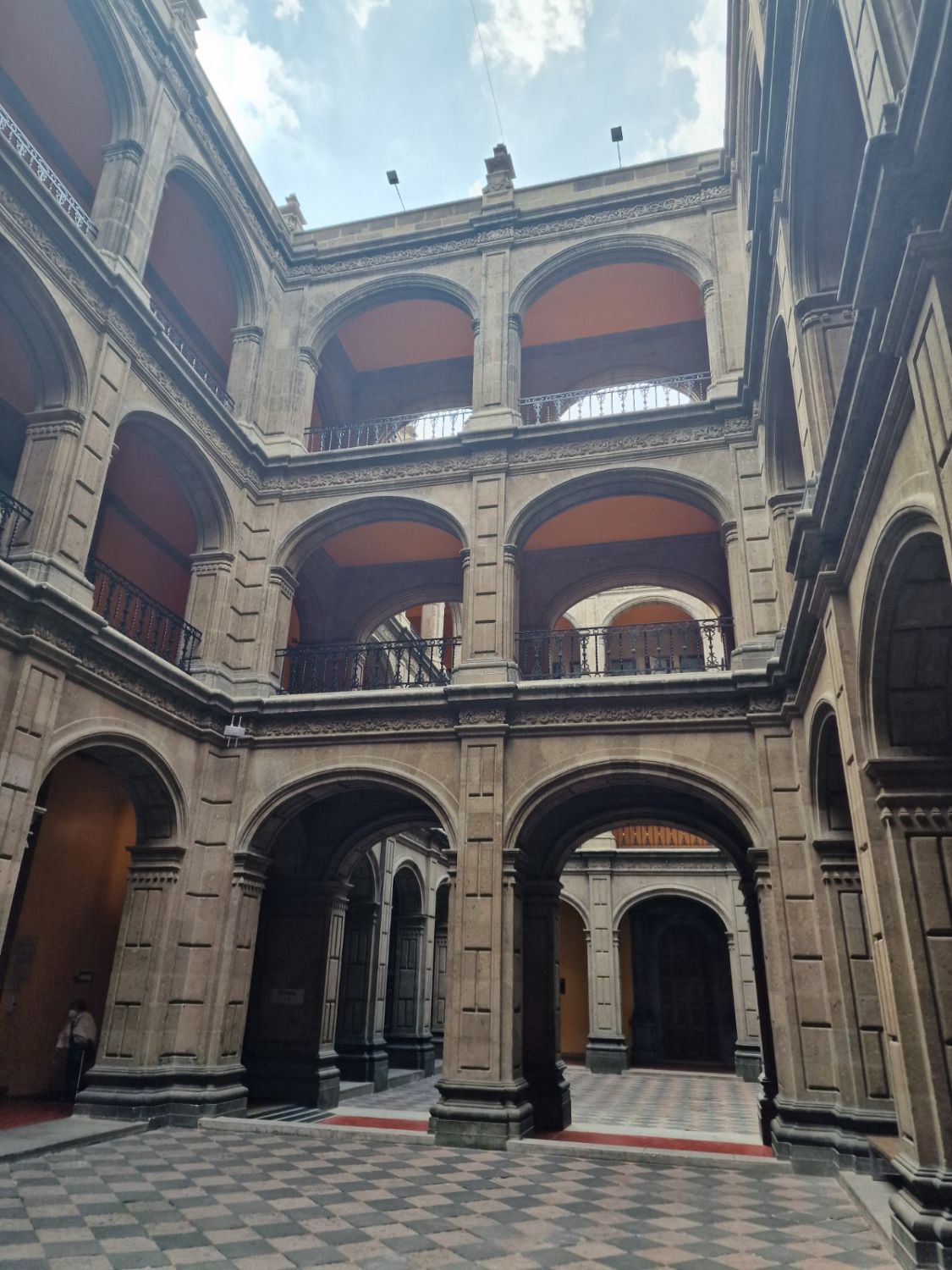 Patio principal del colegio con tres pisos de arquerías de cantera