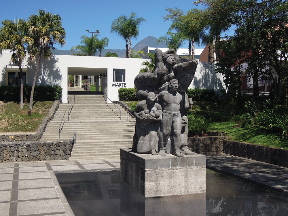 Exterior del Museo de Arte de El Salvador, con el conjunto escultórico del Monumento a la Revolución en primer término.