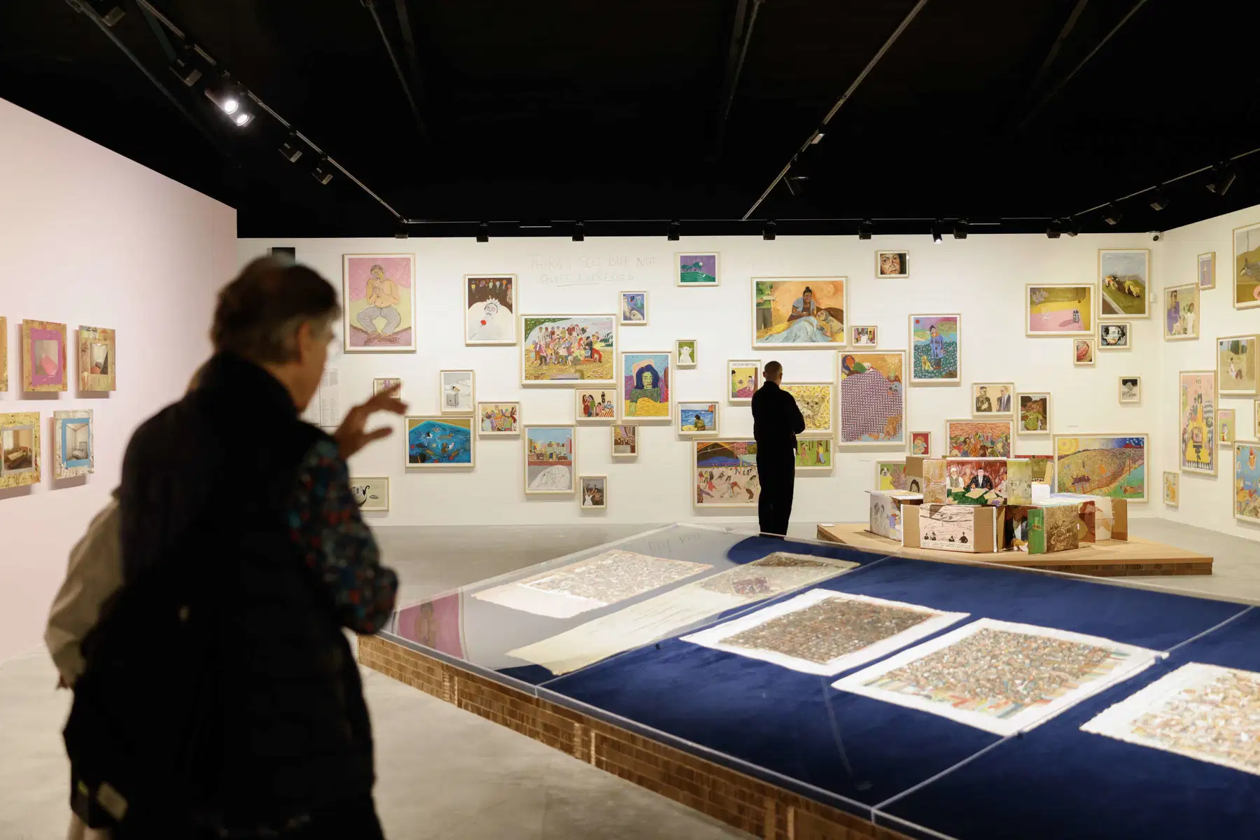 Muro con salón denso de pequeñas pinturas y dibujos figurativos